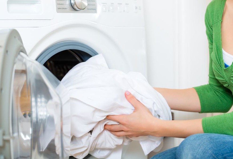 TENSAGEX brand banner - putting laundry in a washing machine